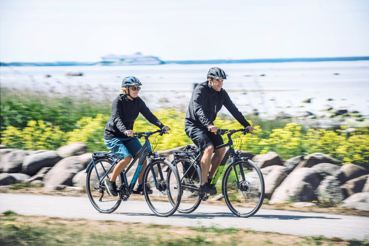 Glückliches Pärchen bei langer Radtour mit Trekking e Bikes und super Satteln.